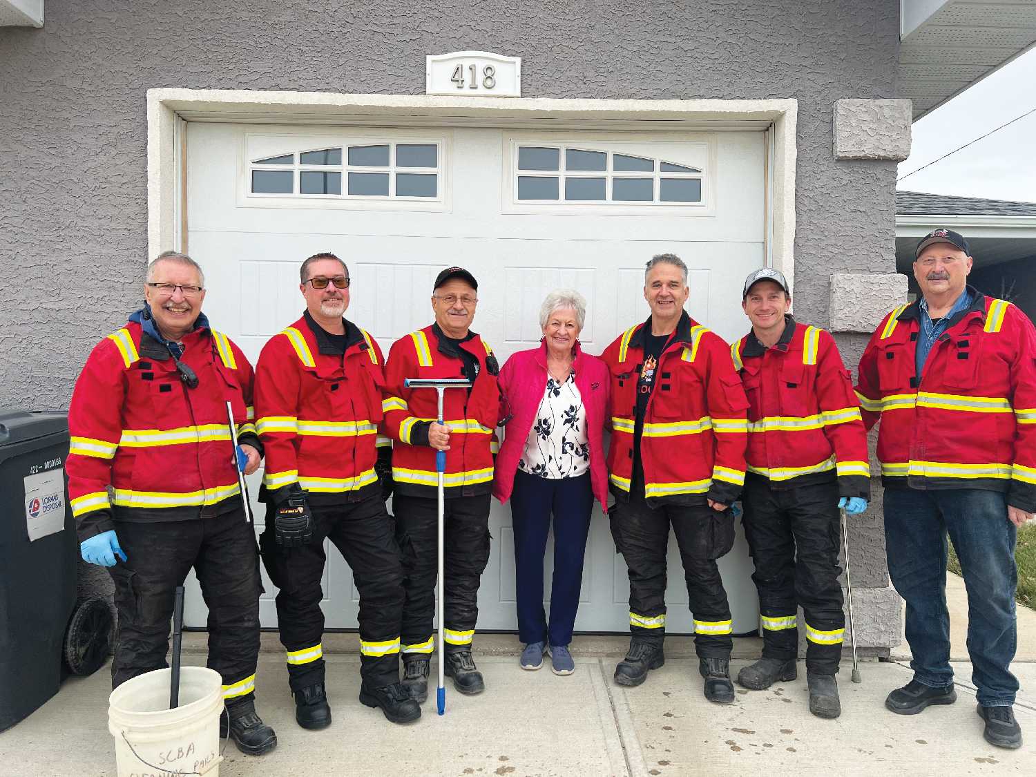Left to right: Esterhazy firefighters Ken Dick, Dave Esslinger, and Allan Babyak, Helen Maga, and firefighters Clint Hollingshead, Jason Polvi, and Borden Kishalowich. The firefighters were washing windows on November 15, including Helen Magas windows, as part of their donation of time that was auctioned off and purchased by Peter Carscadden Funeral Chapel. Peter Carscadden Funeral Chapel decided to use the firefighters time to help the elderly.