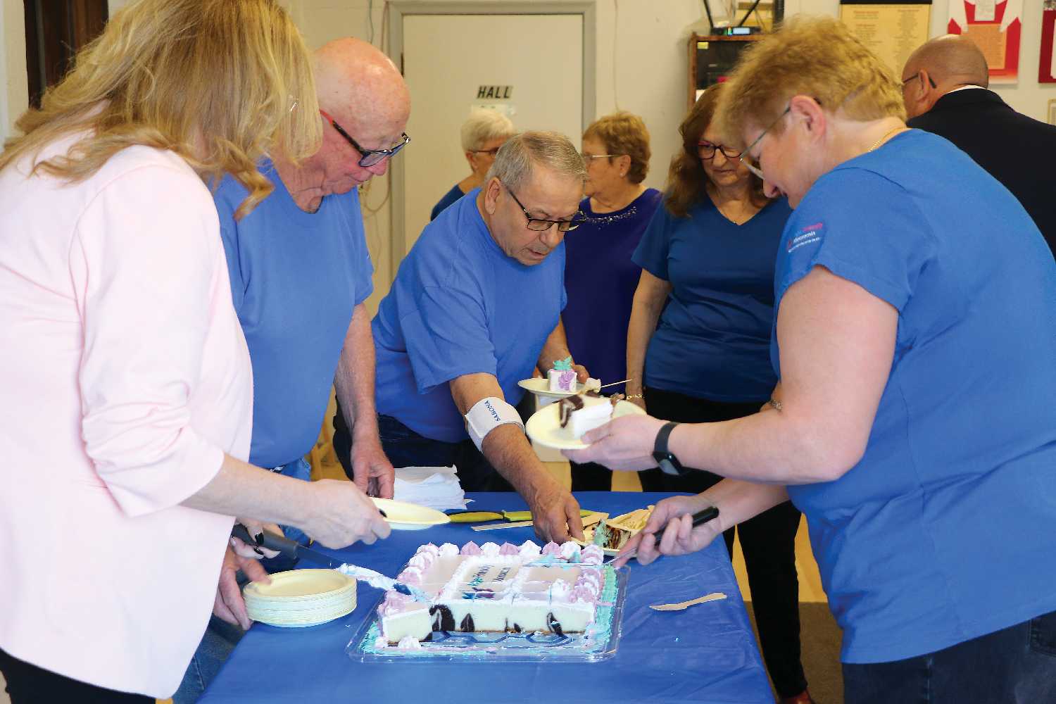 Lori Carr and members of the Age-Friendly Moosomin committee cutting the cake at the event.