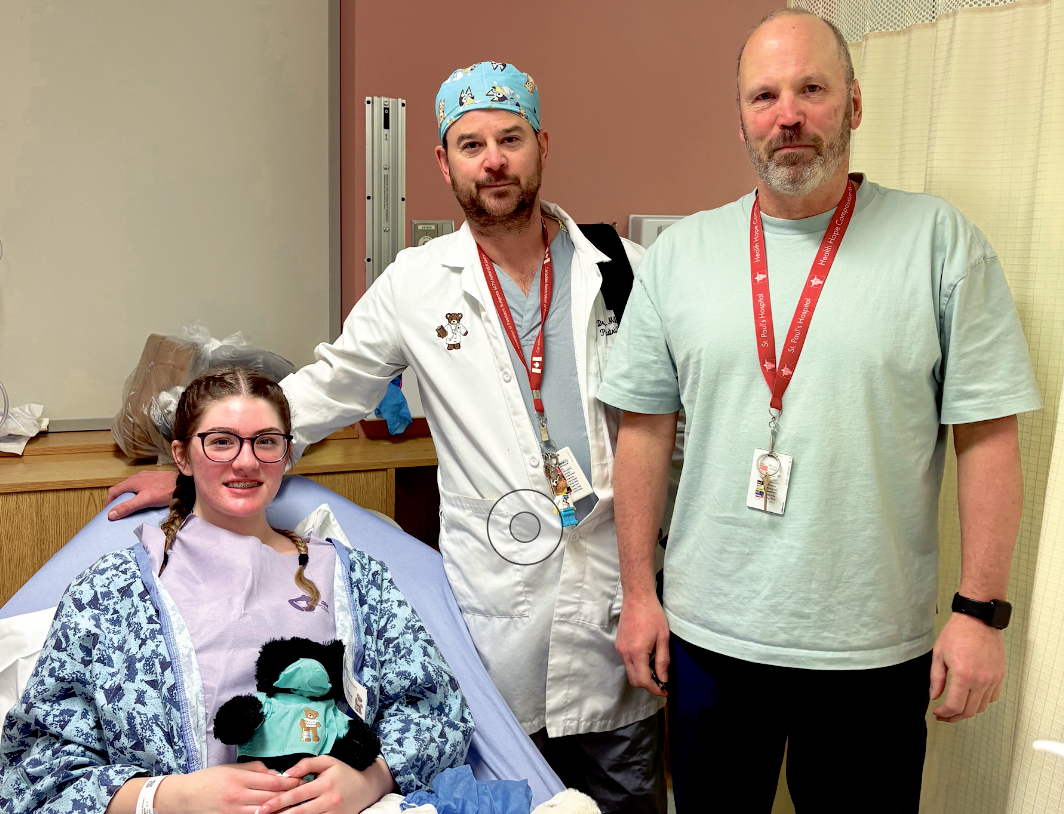 Mikka with pediatric surgeon Dr. Milbrandt (in white coat and scrub cap) from Jim Pattison Childrens Hospital, and Dr Bigsby, thoracic surgeon from St. Pauls hospital where the surgery took place to be done with their robotic system. Mikkas surgery was so rare, her pediatric surgeon had never performed a total gastrectomy in his 20-pluls years as a surgeon. Summer says the difference in Mikkas healing/pain level from having robotic surgery vs her open abdominal surgery is absolutely incredible. We are so thankful this technology has been created in the past 10 years to help make Mikkas surgery easier to recover from.<br />
